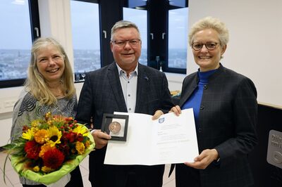 Rainer Mark mit der Bronzemedaille und dem Ehrenbrief, links seine Frau und rechts Sabine Groß.