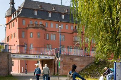 Das Schild Willkommen in Offenbach hängt am Maindamm vor dem Isenburger Schloss.