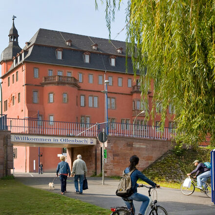 Das Schild Willkommen in Offenbach hängt am Maindamm vor dem Isenburger Schloss.