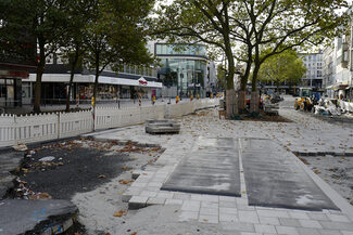 Blick auf eine Baustelle, bei der ein Bürgersteig neu gepflastert wird.