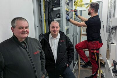 Drei Männer in einem Technikraum.