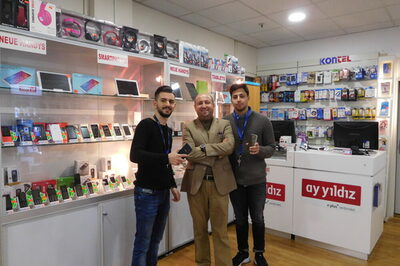 Sait Özcan mit Auszubildenden in seinem Mobilfunkladen