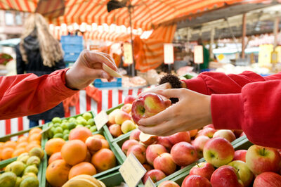Ein Besucher probiert auf dem Offenbacher Wochenmarkt ein Stück Apfel.