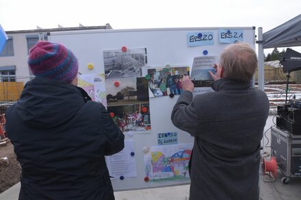 Stadtrat Paul-Gerhard Weiß und Schulleiterin Sabine Henning vor einer Stellwand mit Fotos.