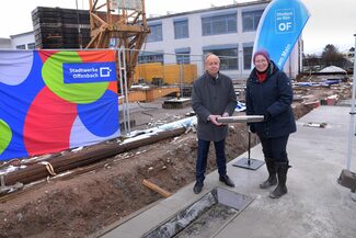 Stadtrat Paul-Gerhard Weiß und Schulleiterin Sabine Henning halten die Zeitkapsel in den Händen.