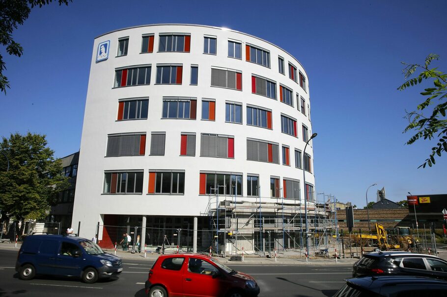 Ein halbrunder Anbau an der Mathildenschule. Die Fassade ist weiß, die Fenster haben rote Seitenstreifen.