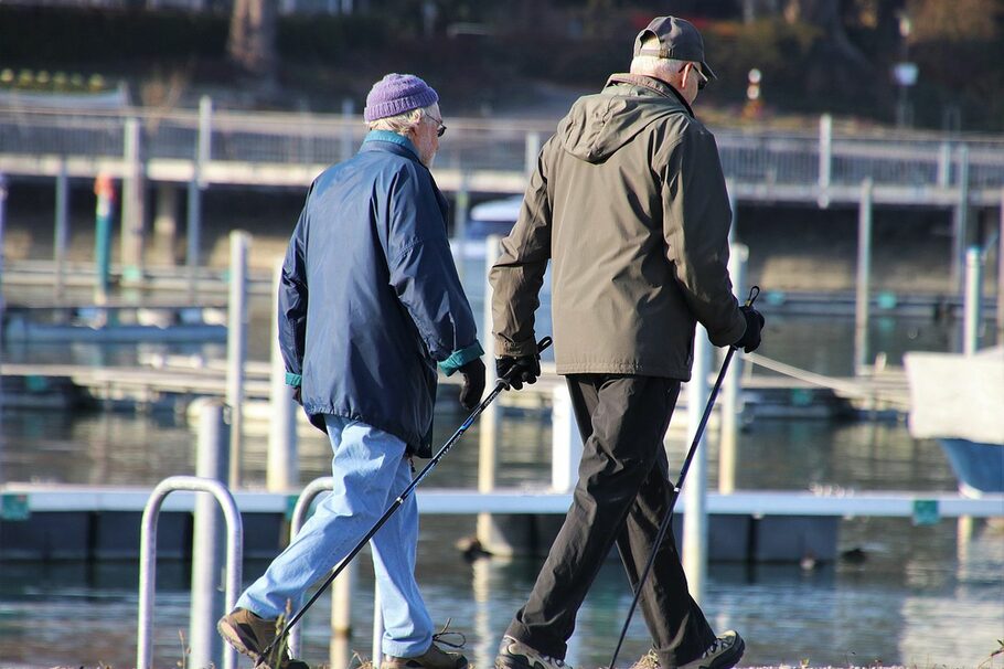 Zwei Senioren, einer mit Walking-Stöcken