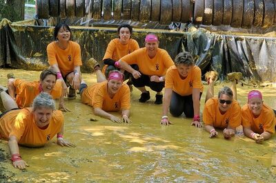 Frauen in orangenen T-Shirts im Matsch