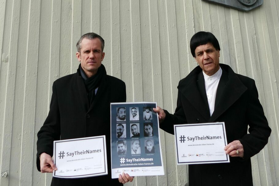 Zwei Männer halten Schilder mit dem Hashtag
