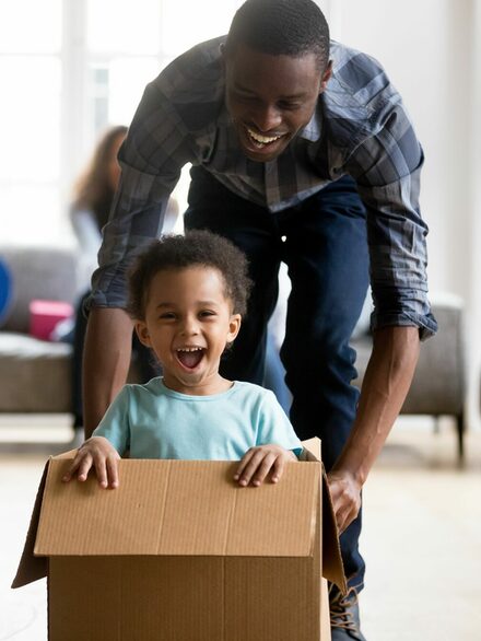 Boy in a moving box  having fun with his father