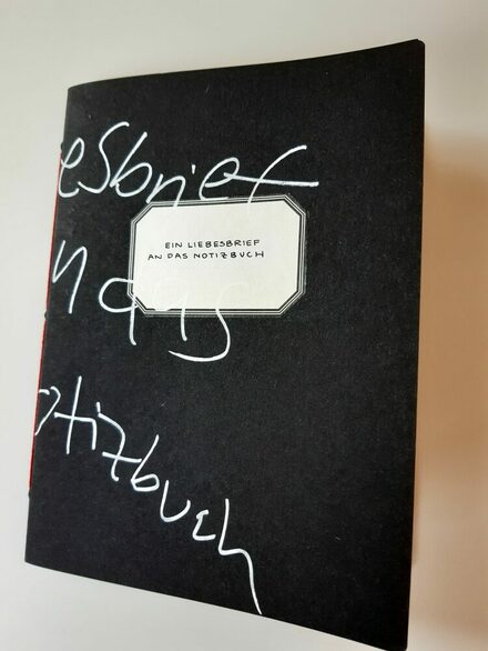 Eine schwarze Kladde beschrieben mit "Liebesbrief an ein Notizbuch"
