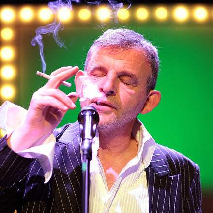 Der Schauspieler Dominique Horwitz raucht und singt.
