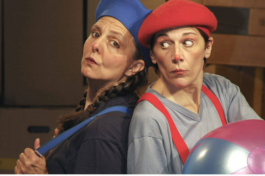 Eine Frau mit blauer Kappe und Zöpfen, eine mit roter und roter Nase