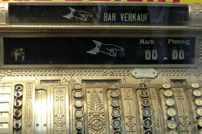 Das Foto zeigt eine alte Registrier-Kasse mit Ziffernknöpfen und einer Anzeige, auf der Bar Verkauf, D-Mark und Pfennig steht.
