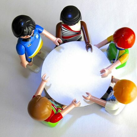 Playmobilfiguren an einem runden Tisch