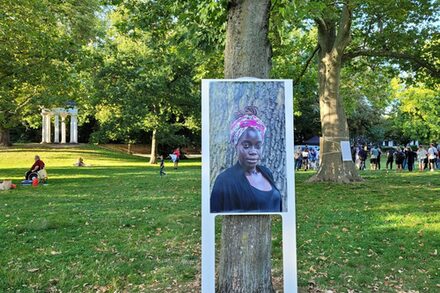 Porträtfoto auf Plakatständer von einer Frau mit Migrationshintergrund