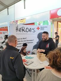 Zu sehen ist der Stand des Deutschen Roten Kreuzes mit Menschen.