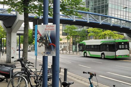 Ein Plakat mit Informationen hängt an einem Fahrradstellplatz.