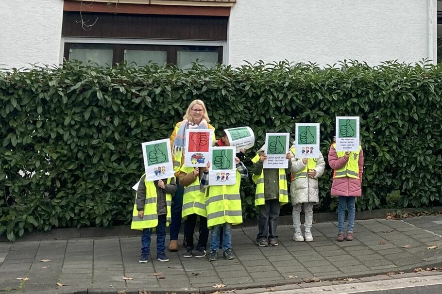Kinder und Lehrerin mit Smiley-Plakaten