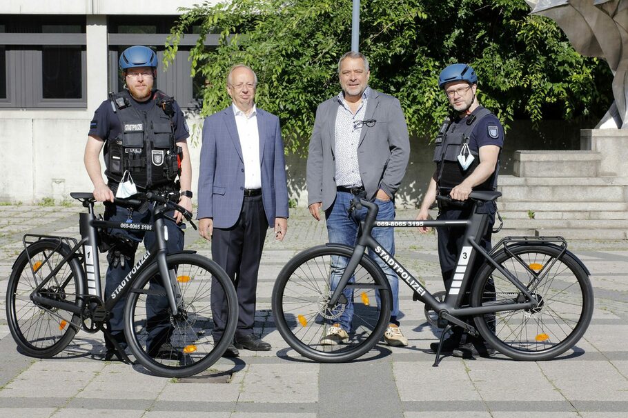 Paul-Gerhard Weiß und Lothar Haack stehen zwischen zwei Stadtpolizisten, die ihr Fahrrad präsentieren.