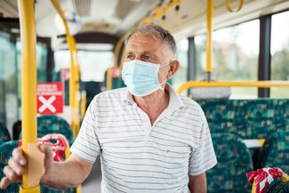Älterer herr mit maske im Bus
