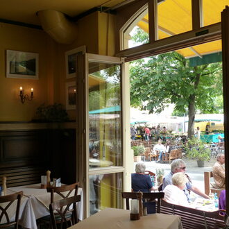 Blick aus dem Fenster eines Restaurants am Wilhelmsplatz, im Hintergrund der Wochenmarkt.