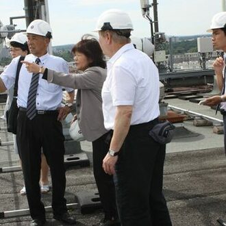 Mitglieder der japanischen Delegation auf dem Turm des EVO-Kraftwerks.