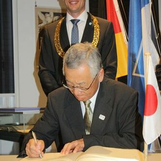 Bürgermeister Yoshiaki Kawai trägt sich ins Goldene Buch ein
