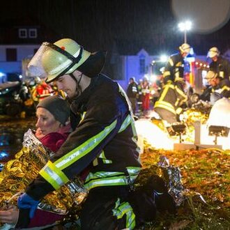 Feuerwehrmann hilft auf dem Boden liegenden Verletzten