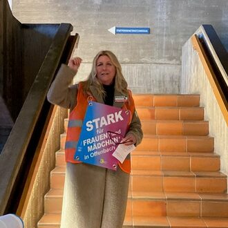Frauenmarsch, eine Frau hält eine Rede auf der Treppe im Rathaus