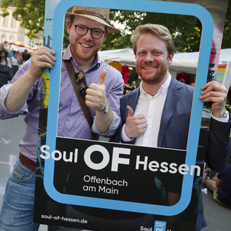 Zwei Männer mit Fotorahmen aus Pappe auf dem Soul OF Hessen steht.