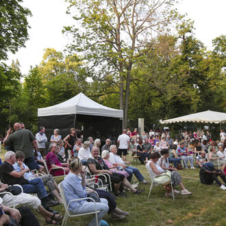 Besucherinnen und Besucher genießen im Lili-Park das Programm auf der Bühne des Jazz e.V.