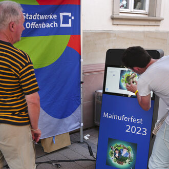 Ein Besucher macht am Stand der Stadt / Stadtwerke Offenbach ein Erinnerungsfoto.