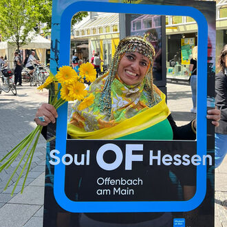 Eine Frau mit einem Fotorahmen auf dem Soul OF Hessen steht.