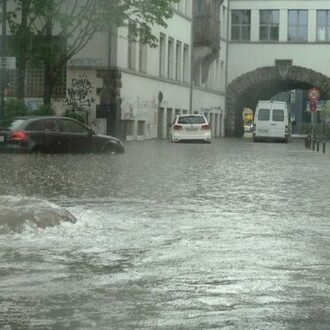 Autos stehen im Wasser wegen eines Starkregens.