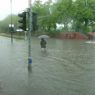 Eine Person läuft über die überflutete Mainstraße in Offenbach.