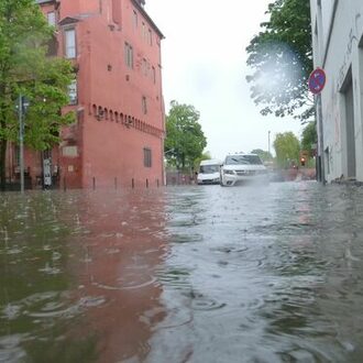 Autos stehen in überfluteten Bereichen aufgrund eines Starkregens.