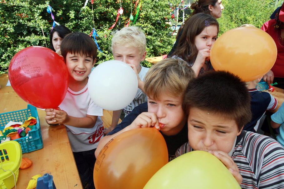 Kinder beim Luftballon aufblasen
