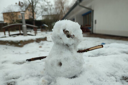 Die Kinder nutzten die Gelegenheit den ersten liegen gebliebenen Schnee dazu, ein Schneemaskottchen für die Kita zu bauen.