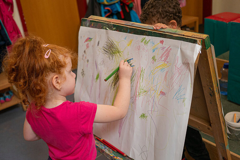 Kind malt an einer Staffelei in einer EKO-Kita