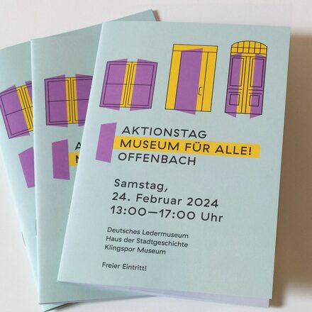 Auf dem Bild sind Hefte zum Aktionstag "Museum für alle! Offenbach" zu sehen. Auf den Heften sieht man die Eingangstüren der beteiligten Museen.