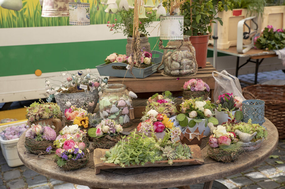 Eine Auswahl an Blumen-Arrangements auf einem Holztisch.