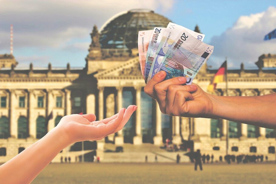 Vor dem Berliner Reichstagsgebäude wird Geld überreicht