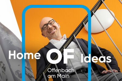 Ein Mann steht hinter dem Geländer einer Treppe, die Wand hinter ihm ist orange gestrichten. Auf dem Bild liegt das Offenbach Logo sowie der Kampagnen-Slogan.