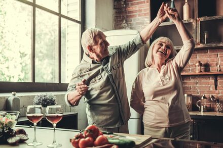 Tanzendes Seniorenpaar in einer Küche