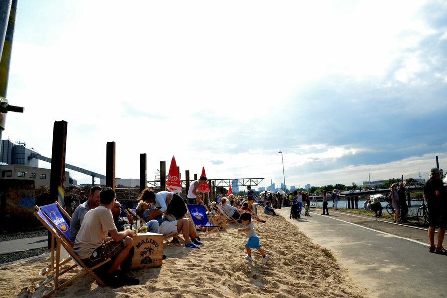 Besucher im Strandbereich am Mainufer während des BRückenfestes im Hafen.