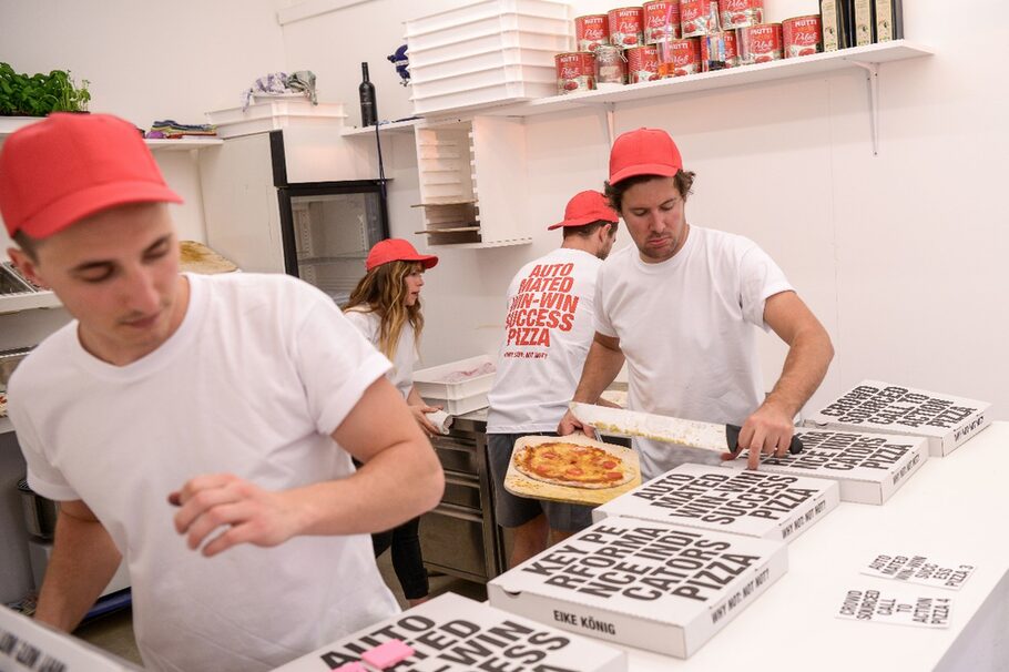 Kunstaktion der Gruppe YRD.Works: Pizzabäcker legen Pizza in Kartons.