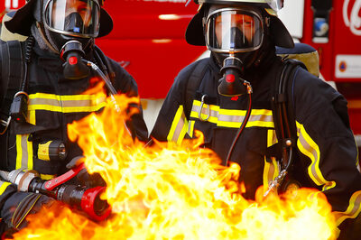 Zwei Feuerwehrmänner mit Flammenwerfern