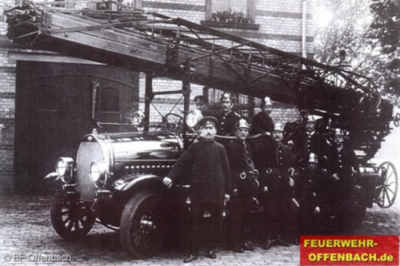 Schwarz-weiss Aufnahme Feuerwehrmänner posieren vor dem Fahrzeug