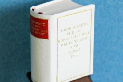 Buch mit dem Grundgesetz auf einem kleinen Holztischchen